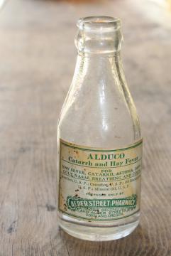 catalog photo of vintage glass medicine bottle w/ old paper label Alder St pharmacy Portland Oregon