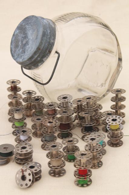 photo of vintage glass store counter candy jar full of old metal thread bobbins #1