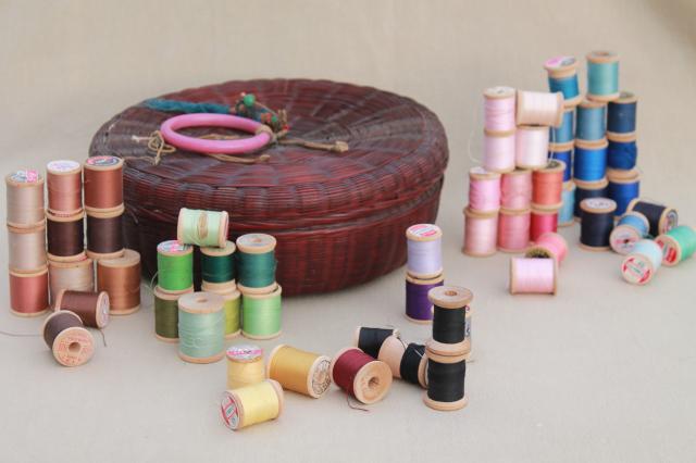 photo of vintage round wicker sewing basket full of spools of colored cotton thread #1