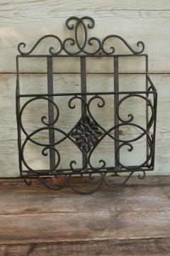 catalog photo of vintage wrought iron magazine rack, heavy ornate black metal wall mount hanging storage 