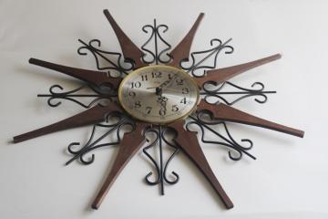 catalog photo of working 70s vintage Welby sunburst wall clock, black iron with wood rays MCM 